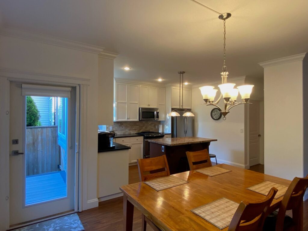 Dining table with kitchen in background and rear door exit